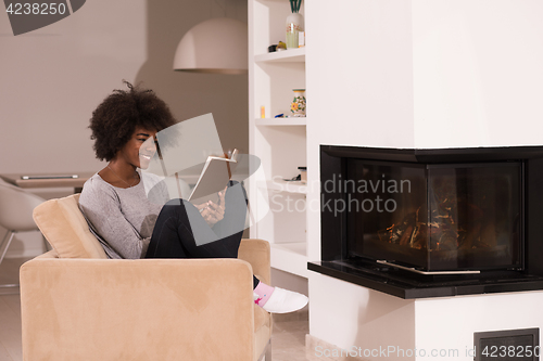 Image of black woman at home reading book