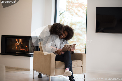 Image of multiethnic couple hugging in front of fireplace