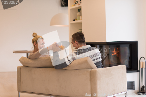 Image of Young couple  in front of fireplace