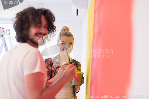 Image of couple painting interior wall