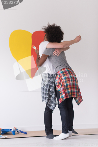 Image of couple with painted heart on wall