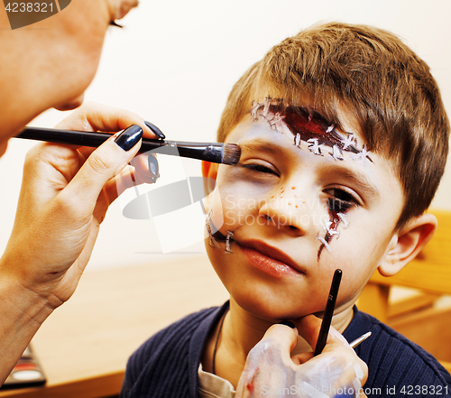 Image of little cute child making facepaint on birthday party, zombie Apo