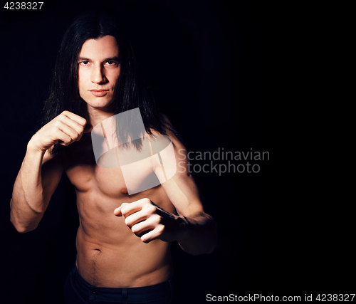 Image of handsome young man with long hair naked torso on black backgroun