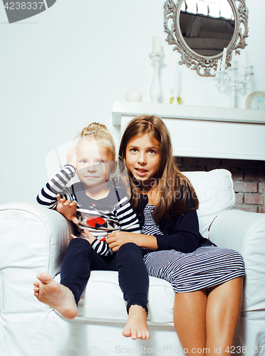 Image of two cute sisters at home interior playing, little happy smiling 