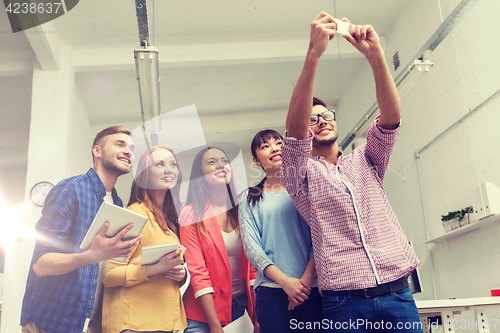 Image of creative business team taking selfie at office