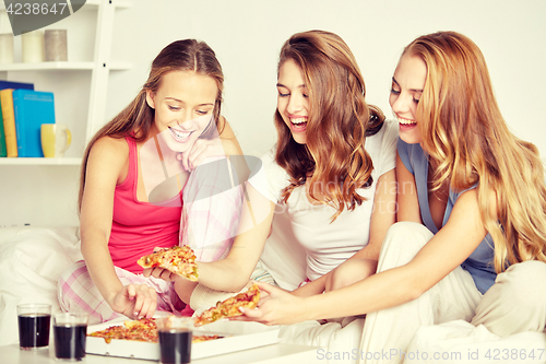 Image of happy friends or teen girls eating pizza at home