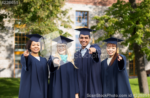 Image of happy students or bachelors pointing finger at you