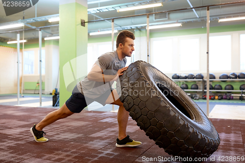 Image of man doing strongman tire flip training in gym