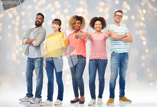 Image of international group of happy people over lights