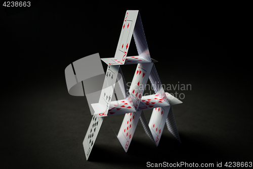 Image of house of playing cards over black background