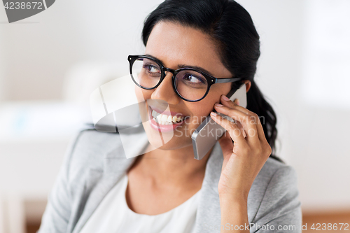 Image of businesswoman calling on smartphone at office