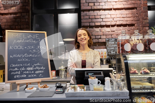 Image of happy woman or barmaid at cafe counter