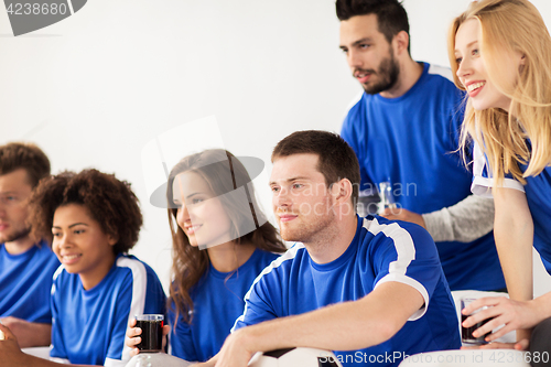 Image of friends or football fans watching soccer at home