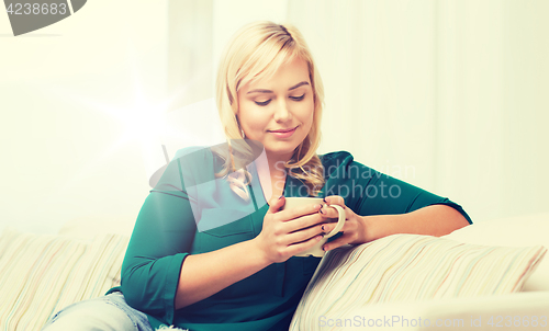 Image of happy woman  with cup of tea or coffee at home