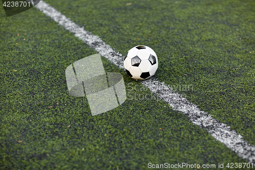 Image of soccer ball on football field marking line