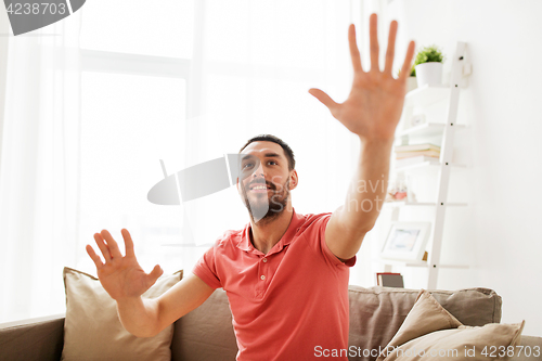 Image of happy man touching something imaginary at home