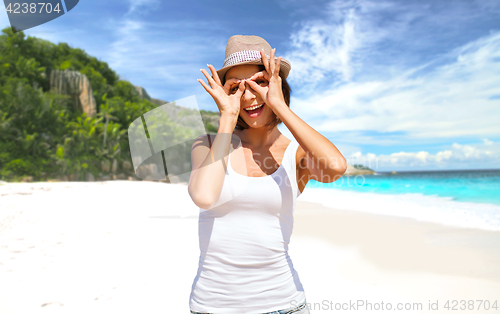 Image of happy young woman in hat on summer beach