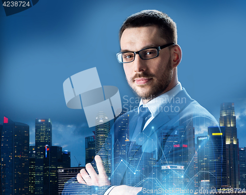 Image of businessman in glasses over night singapore city