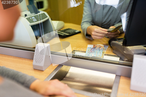 Image of clerk counting cash money at bank office