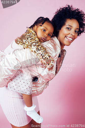 Image of young pretty african-american mother with little cute daughter hugging, happy smiling on pink background, lifestyle modern people concept 