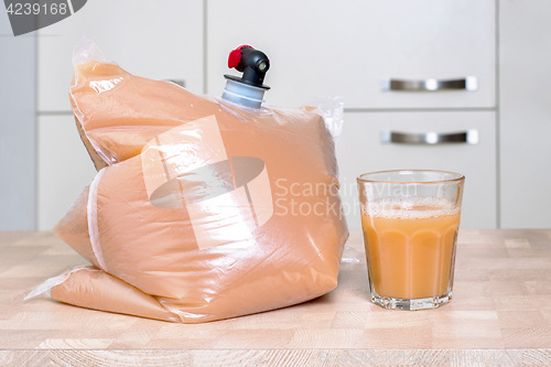 Image of Plastic bag and glass full of apple juice