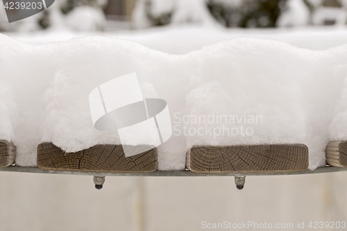 Image of snow on the bench