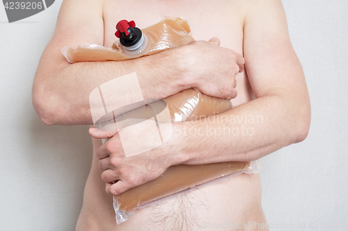 Image of Man holding plastic bag with tap full of apple juice