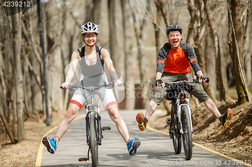 Image of Funny bicyclists driving around park