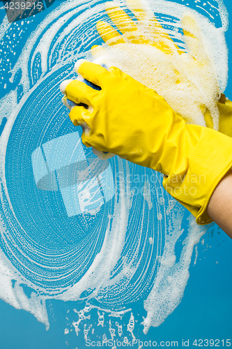 Image of Window cleaner in yellow gloves