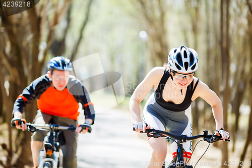 Image of Man, woman riding on bicycles