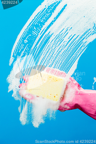 Image of Man washes glass with sponge