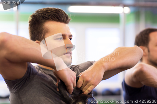 Image of close up of man with kettlebell exercising in gym