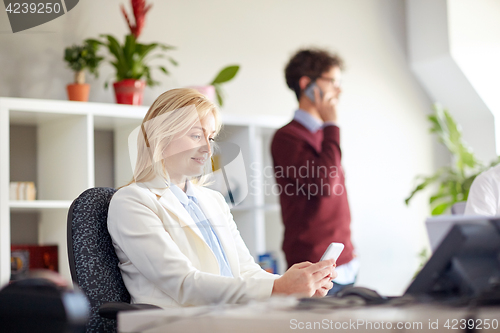 Image of happy businesswoman with smartphones at office
