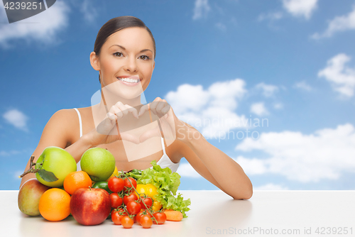 Image of woman with fruits and vegetables showing heart