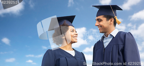 Image of happy students or bachelors in mortar boards