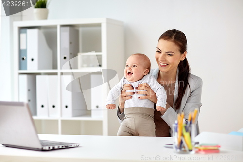 Image of happy businesswoman with baby working at office