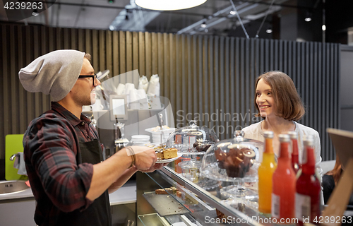 Image of man or barman with cake serving customer at cafe