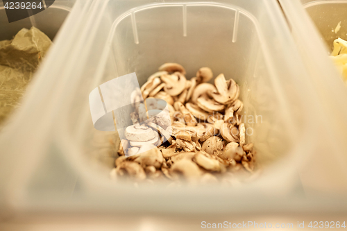 Image of container with champignons at restaurant kitchen