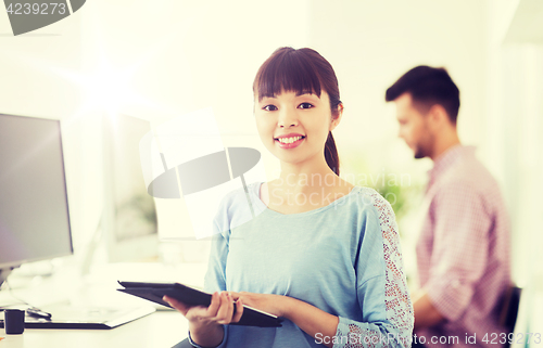 Image of happy creative female office worker with tablet pc