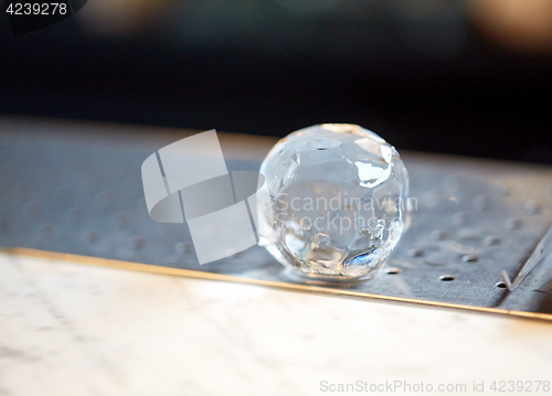 Image of hand-cut ice ball at bar