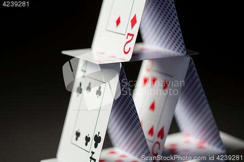 Image of close up of house of playing cards over black
