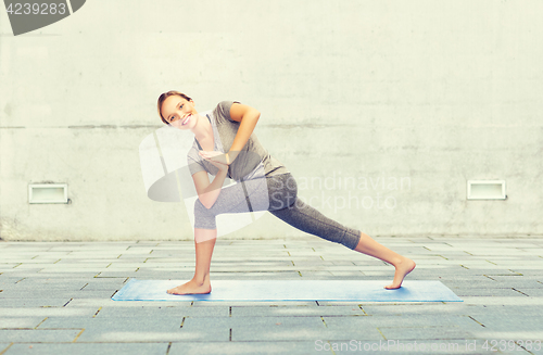 Image of woman making yoga low angle lunge pose on mat