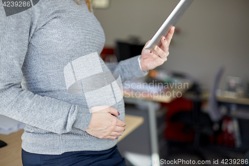 Image of pregnant businesswoman with tablet pc at office