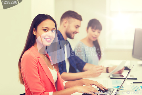 Image of happy african woman over creative team at office