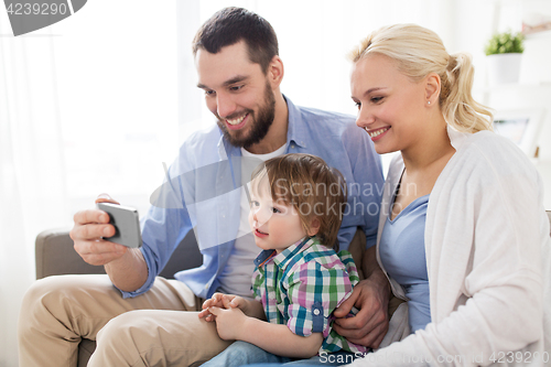 Image of happy family with smartphone at home