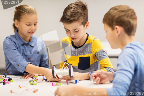 Image of happy children building robots at robotics school