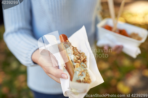 Image of close up of hand with hot dog
