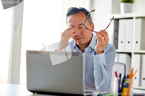 Image of tired businessman with glasses at laptop in office