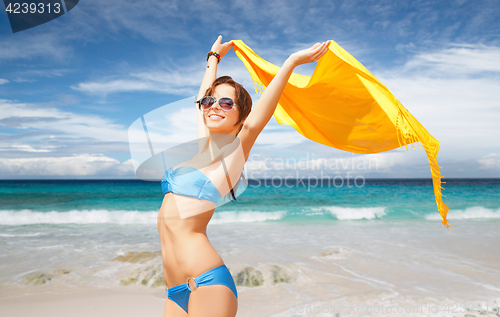 Image of woman in bikini and sunglasses with pareo on beach