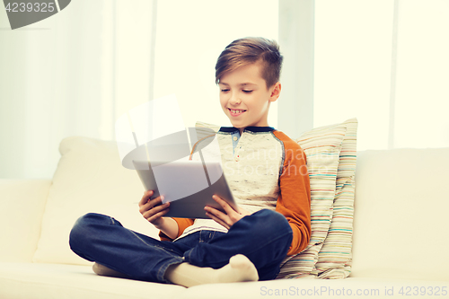 Image of smiling boy with tablet computer at home